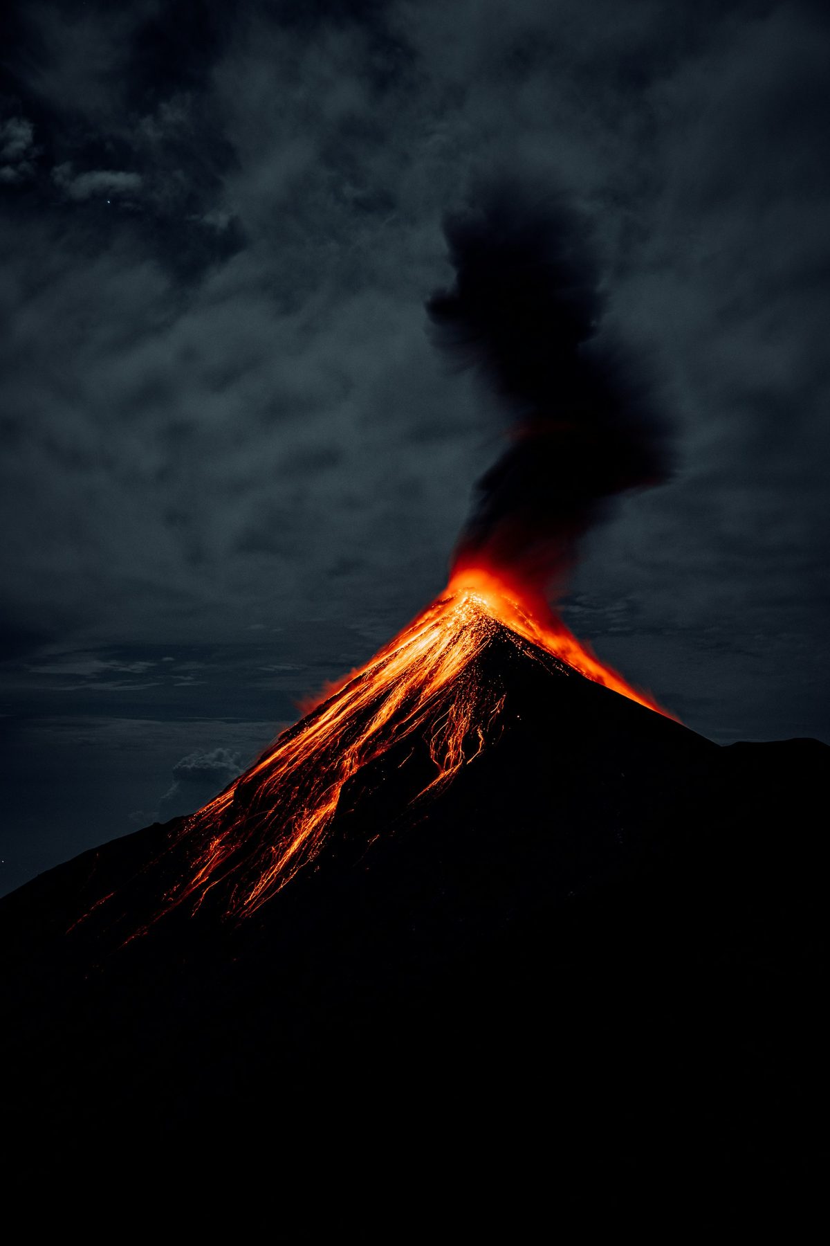 Volcan de Fuego erupting at night with rivers of lava running down its flanks